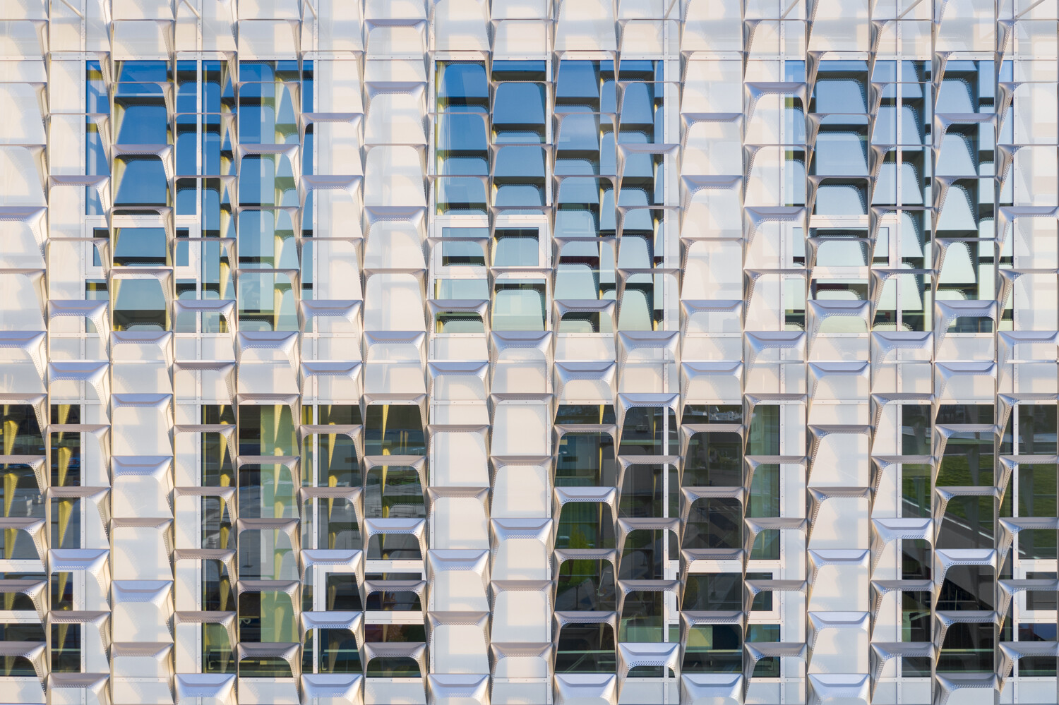 Project by Behnisch Architekturbuero, Harvard University Science and Engineering Complex (SEC). Close-up of the facade with repeating geometric panels and windows, creating a textured grid pattern with light and shadow.